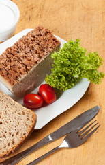 Venison pate on a plate decorated with salad.