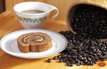 Jam roll and coffee beans on wooden
