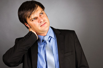 Close up portrait of a young businessman with neck pain