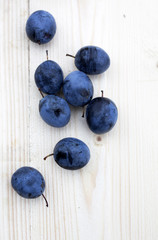 Plums and pear on wooden background