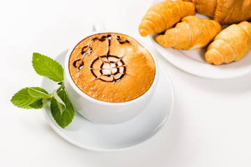 large cup of coffee and croissants on a plate