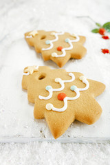 Gingerbread tree cookies on white wood and  snow background