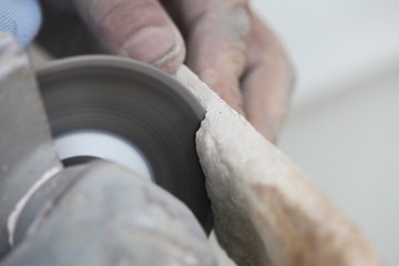 construction worker using an angle grinder cutting tile