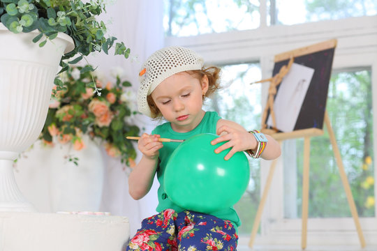 The little painter paints pictures on a green balloon