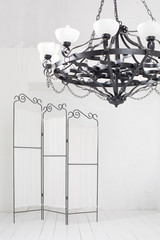 Folding screen and a black chandelier in a room