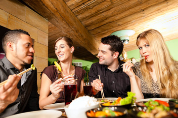 Young people eating in Thai restaurant