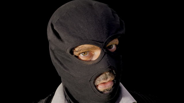 Masked criminal showing gun close up