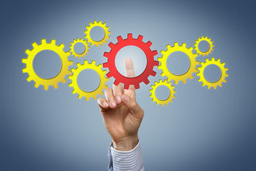 Hand touching display with cogwheels