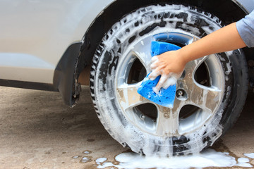cleaning the wheel car wash with a sponge