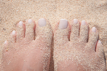 Fototapeta premium Sandy feet on the beach