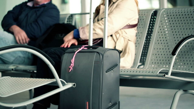 Passengers with suitcase in the airport waiting room