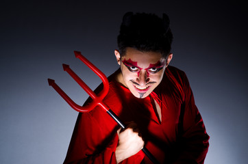 Man in devil costume in halloween concept