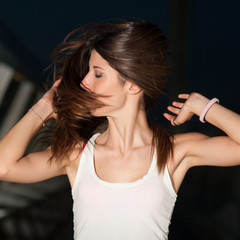 Young woman moving long hair in the night.