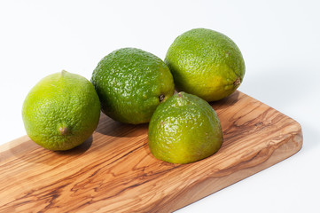 Limes on a wooden table, isolated on white