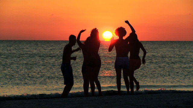 Young College Friends Enjoying Weekend Break Beach Sunset