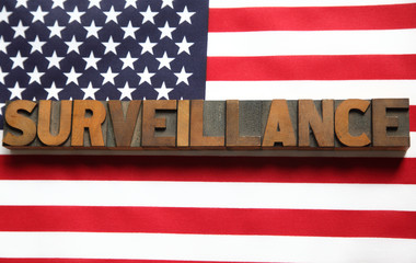 the word 'surveillance' on an American flag