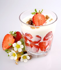 Strawberry with yogurt in glass, cereal and flowers