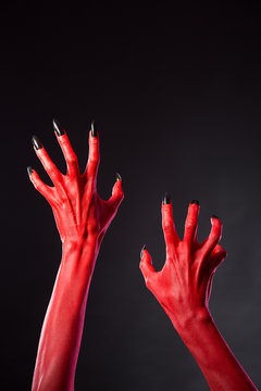Red devil hands with black nails, real body-art