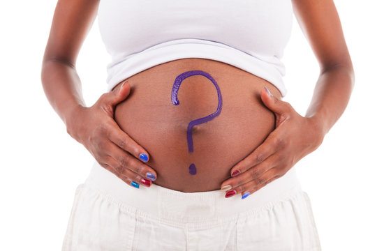 Young pregnant black woman touching her painted belly - African