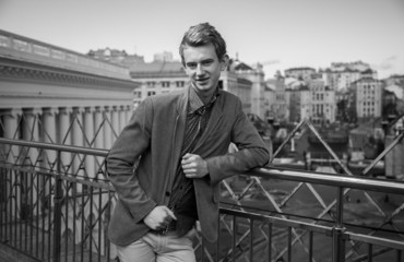 portrait of handsome man standing on rooftop against city view