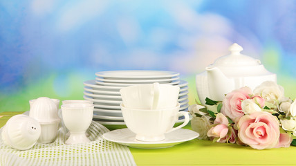 Lots beautiful dishes on wooden table on natural background