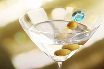 Martini with green olives on table in bar