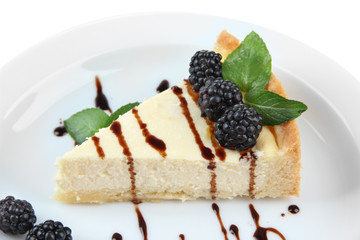 Slice of cheesecake with chocolate sauce and blackberry
