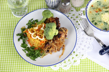 Soup and rice with meat in plates on napkin on tablecloth