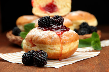 Tasty donuts with berries on wooden table