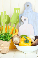 Plastic kitchen utensils in cup on wooden table