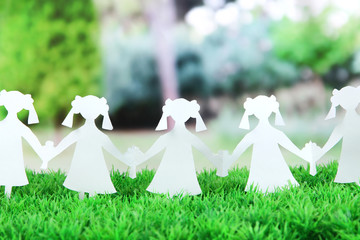 Paper people in social network concept on green grass outdoors