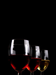 Three wine glasses in line on dark background