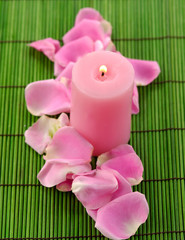 rose petals and candle on green mat