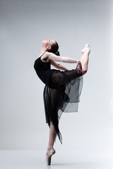 Beautiful ballet-dancer posing on studio background