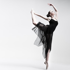 Beautiful ballet-dancer posing on studio background