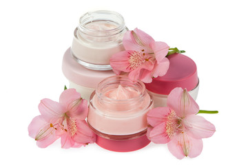 Fototapeta na wymiar Cosmetic cream for make-up and fresh flowers isolated on white b