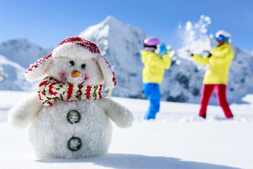 Ski, skiers with snowman enjoying winter