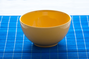 yellow bowl on the blue pad - stock photo