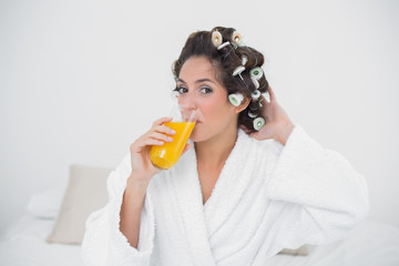 Content natural brunette drinking glass of orange juice