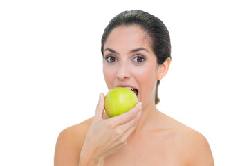 Smiling bare brunette eating green apple