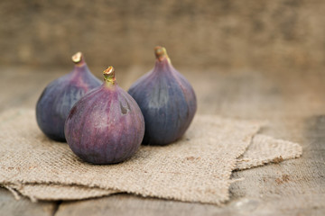 Fresh figs on hessian napkins on wooden background