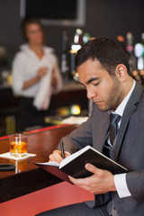 Cheerful businessman writing on his datebook