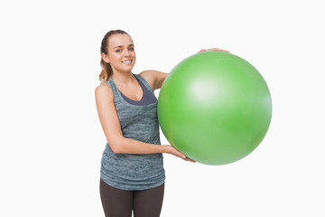 Lovely young woman presenting a fitness ball