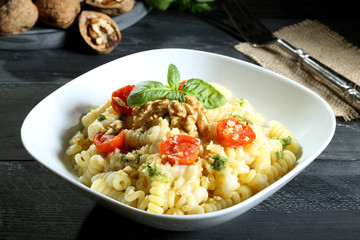 pasta  vegetariana fusilli con verdure e noci sfondo grigio