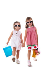Two little girls in sun-glasses and shopping bags