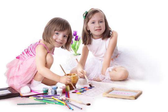 Two little girls drawing with paint
