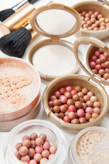 Obraz na płótnie Canvas Women's cosmetics - powder, blush, brushes on the table