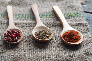 Various spices in wooden spoons