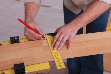 Man measuring slat of parquet
