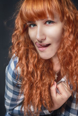 Fototapeta premium red-haired girl shows tongue